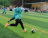 Fussballspielerin, die gerade zu einem Pass auf das Goal ausholt.