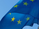 The blue EU flag with its yellow stars waving in the wind