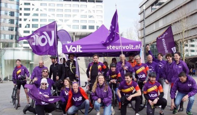 Bild einer Volt Niederlande Standaktion, mit ca. 20 Personen inkl. Zelt, Flaggen etc.